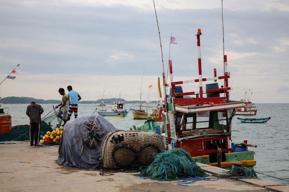 a group of people standing on a dock next to boats