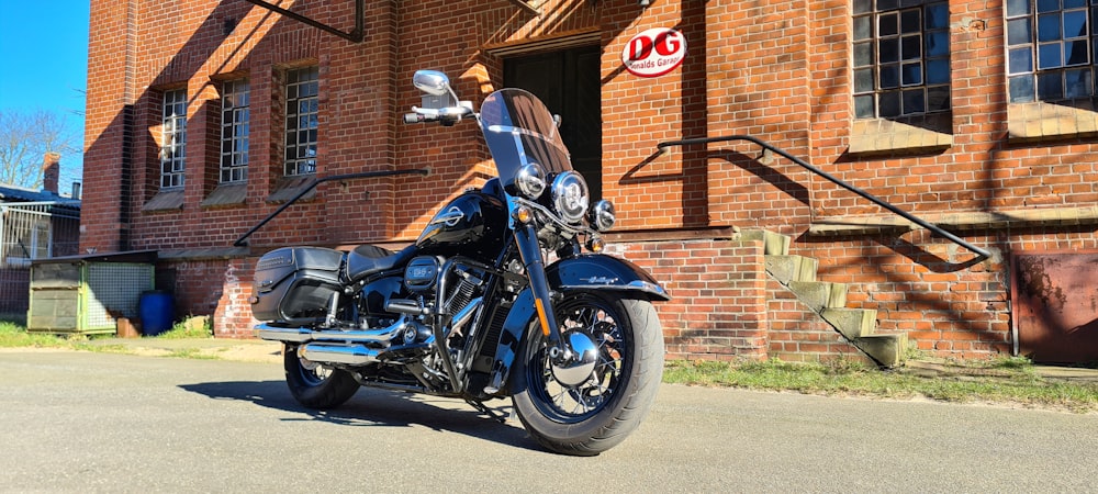 a black motorcycle parked in front of a brick building