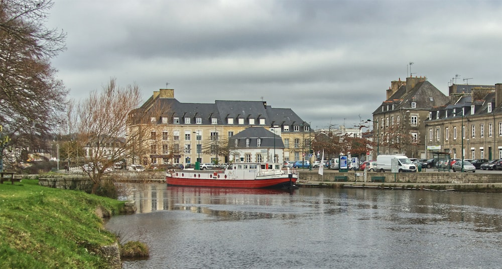 a red and white boat floating on top of a river