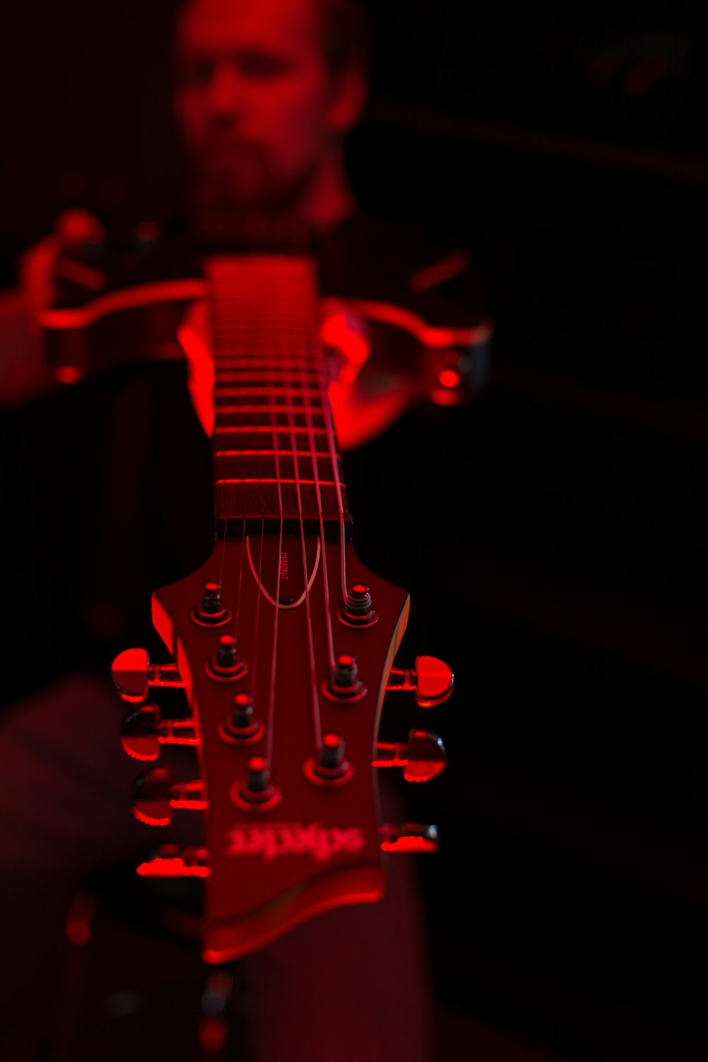 a man holding a guitar in a dark room