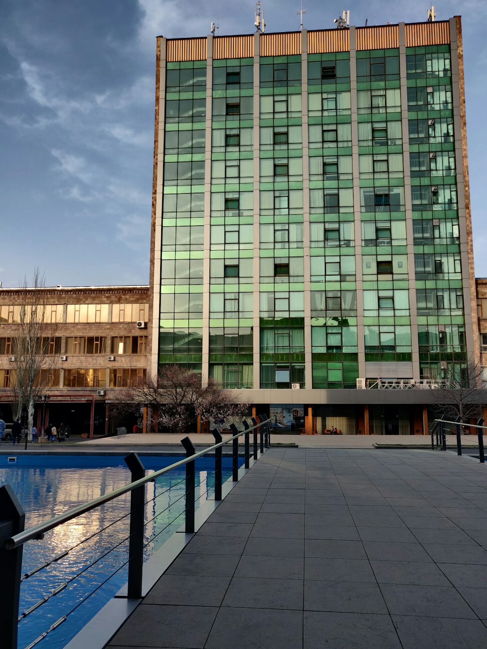 a large building with many windows next to a body of water