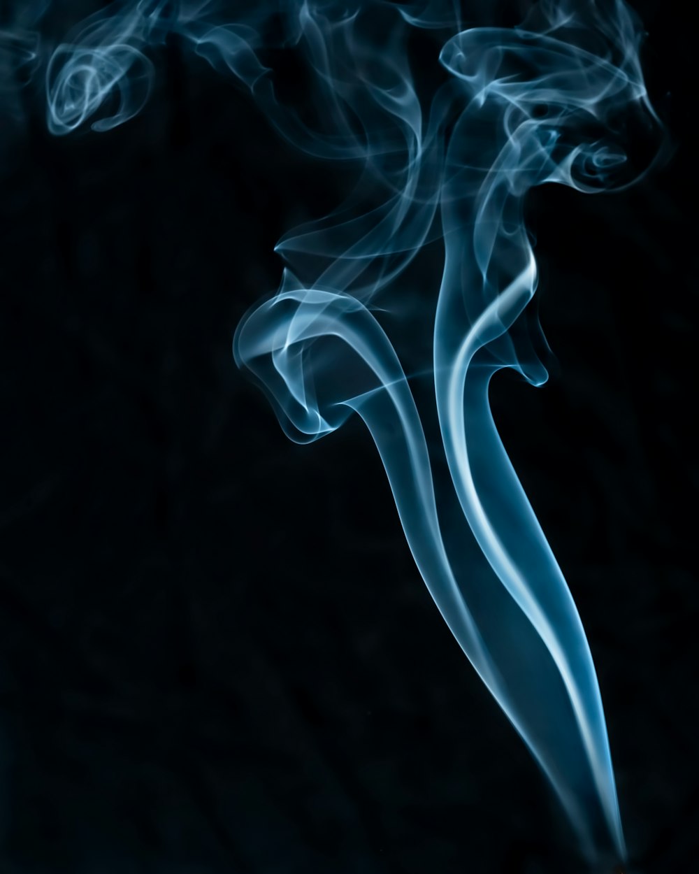 a blue smoke swirls across a black background