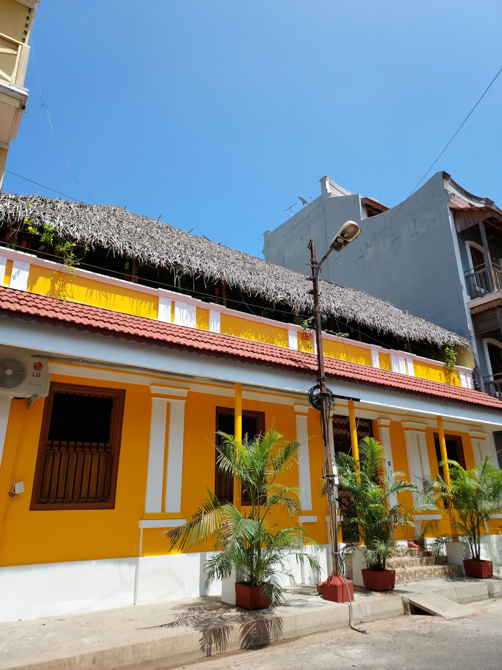 a yellow and white building with a red roof