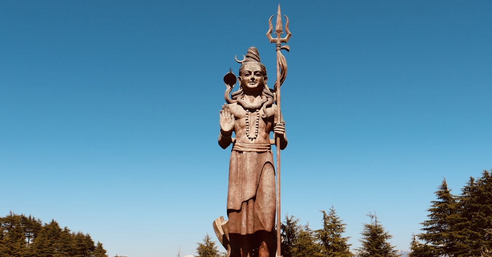 a statue of a person holding a staff