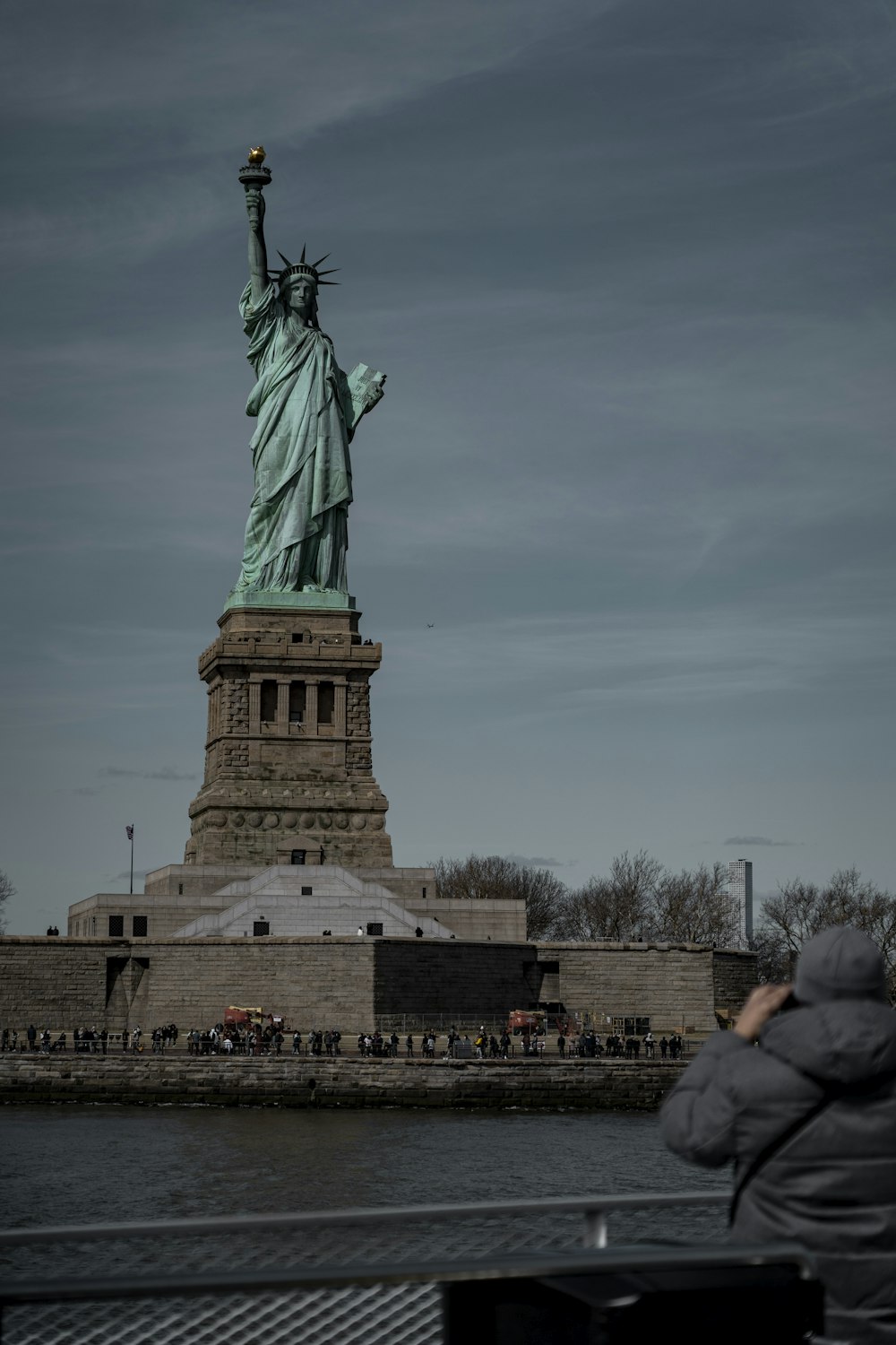a person taking a picture of the statue of liberty