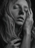 A soft-focus photo of a person smiling quietly, eyes closed, embracing a moment of self-compassion.