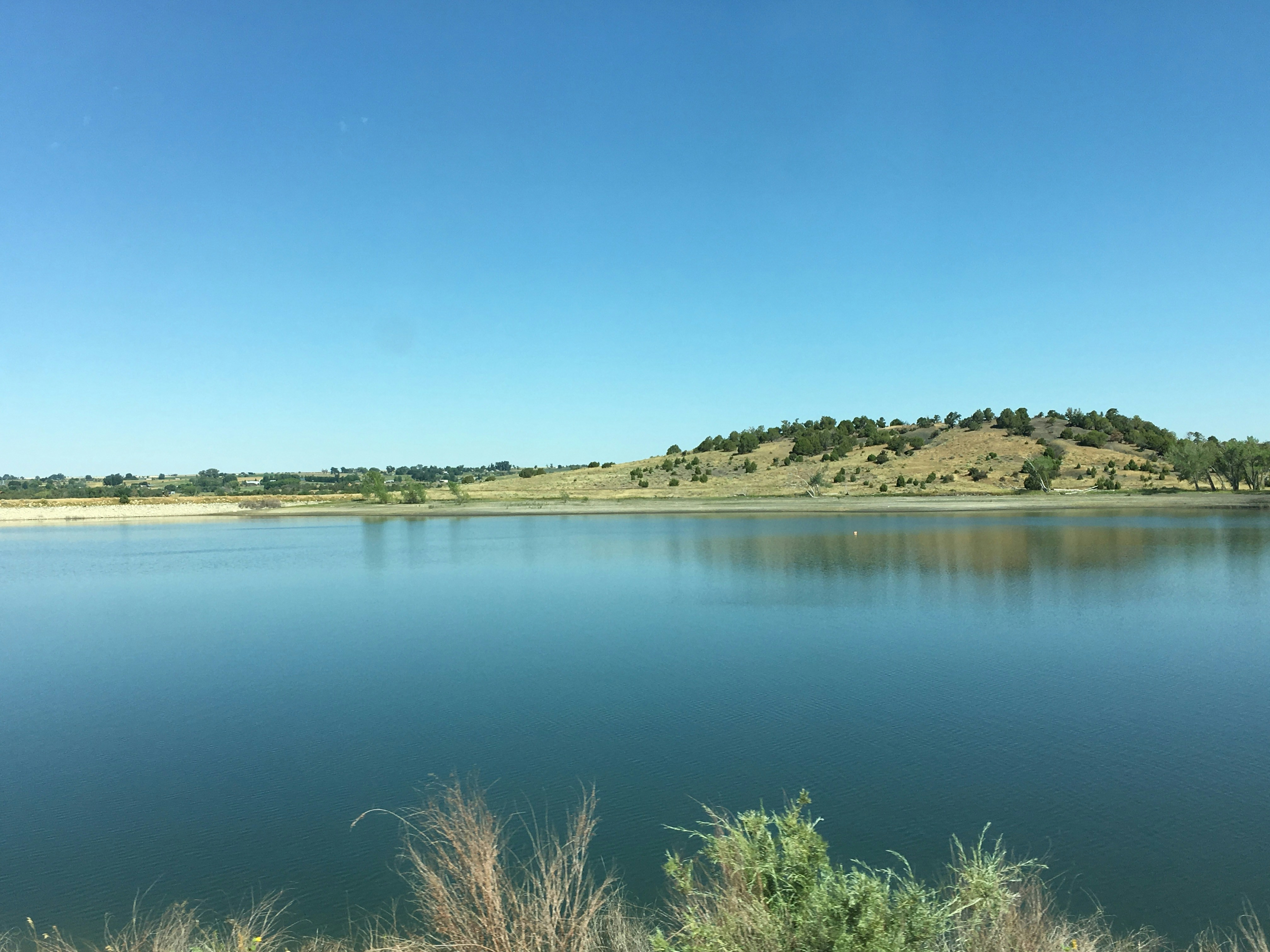 a large body of water with a hill in the background