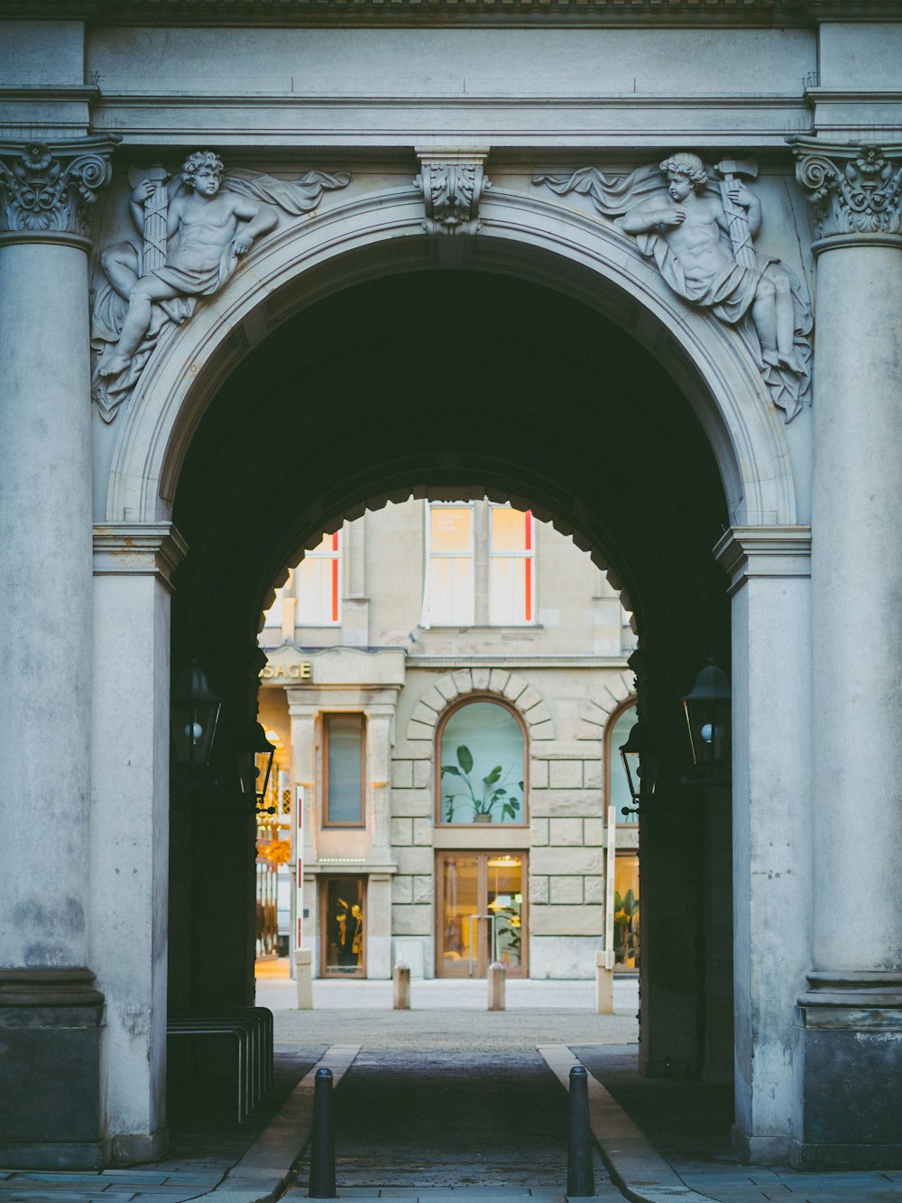 an archway leading into a building with a clock on it