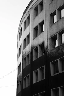 Black and white photo of a modern building facade with soft shadows and gradient lighting.