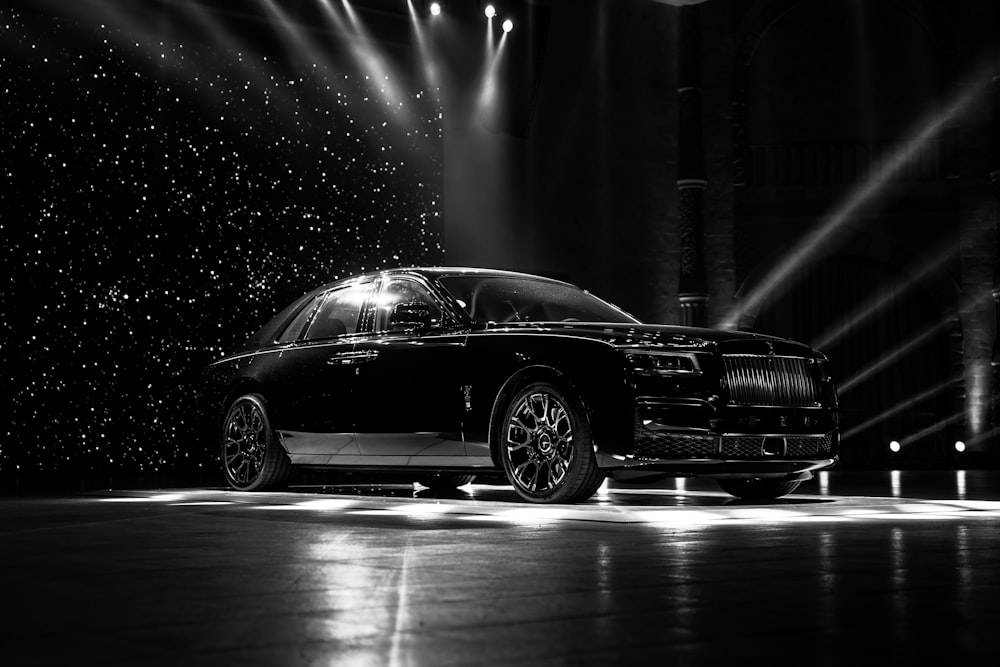 a black and white photo of a car on a stage
