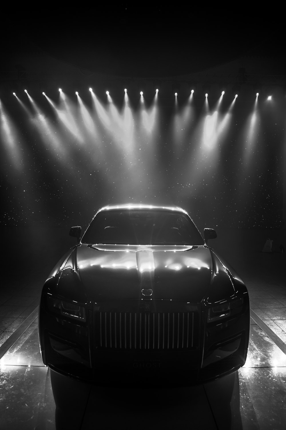 a black and white photo of a car in a spotlight