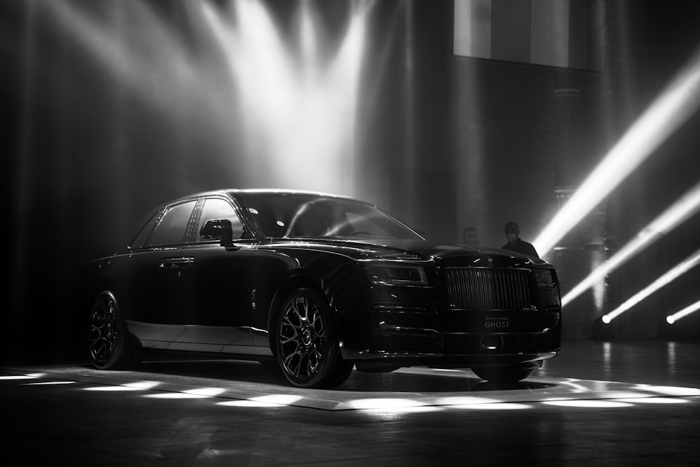 a rolls royce parked in front of spotlights