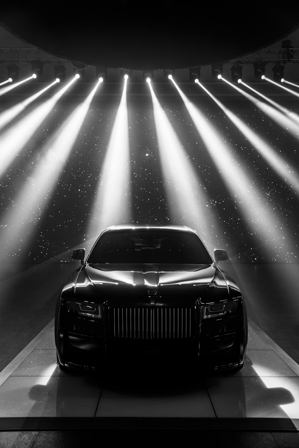 a black and white photo of a car in a showroom