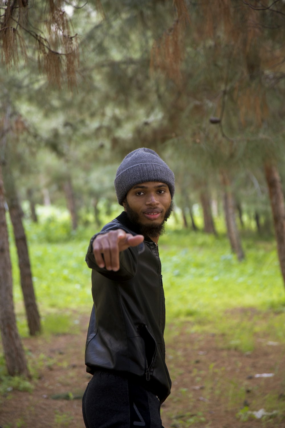 a man pointing at the camera in the woods