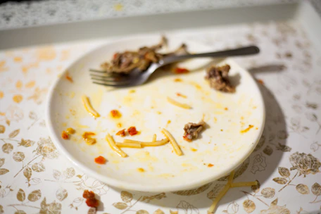 Frustrated person looking at an empty plate with a clock in the background.