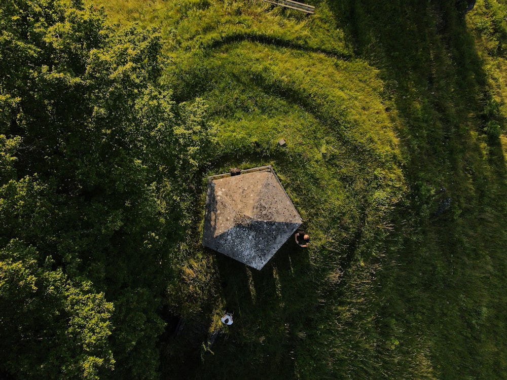 an aerial view of a hut in the middle of a field