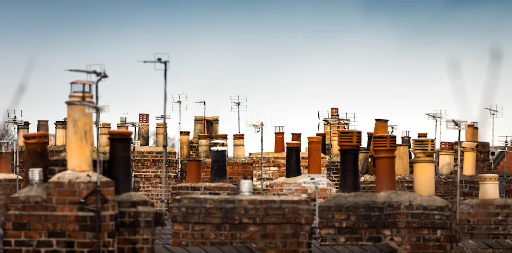 Real residential rooftop brick chimney stacks and chimney pots