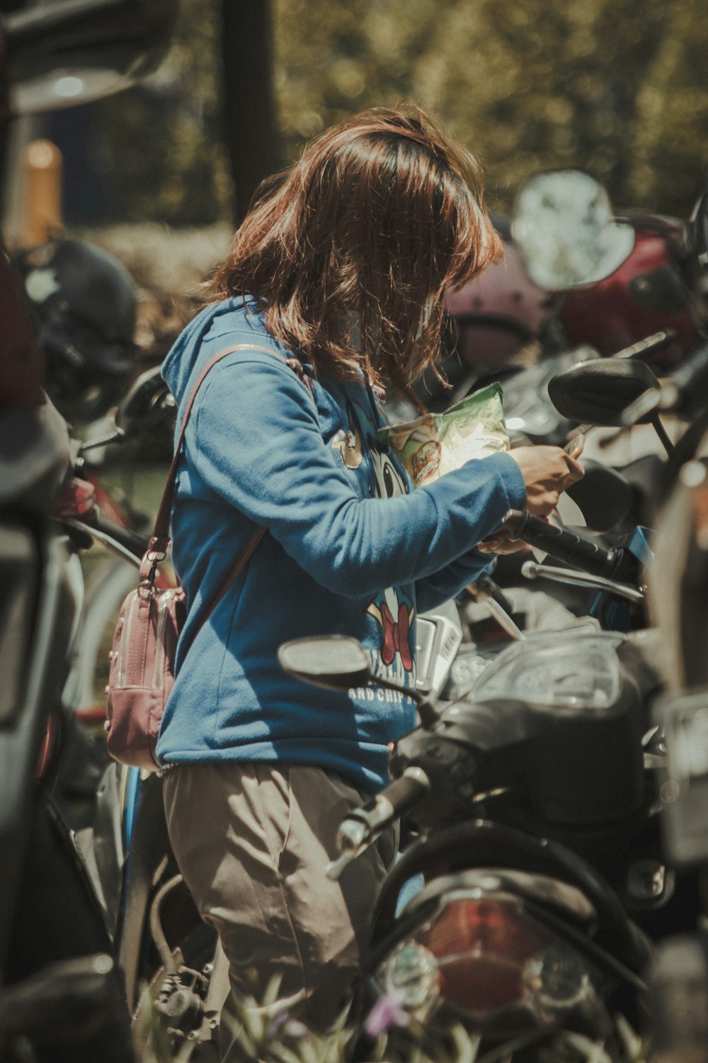 a woman standing next to a bunch of motorcycles