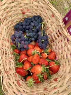 a basket full of strawberries and grapes
