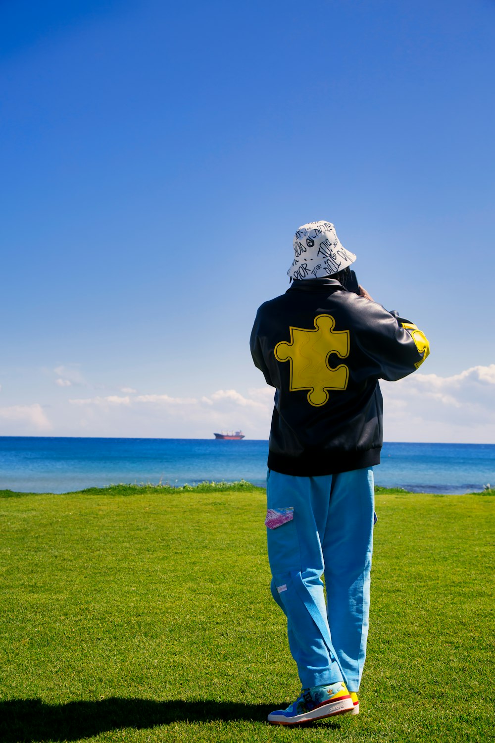 eine Person, die mit einem Puzzleteil auf dem Rücken im Gras steht