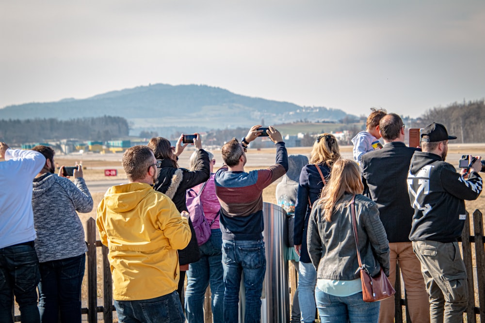 a group of people standing next to each other near a fence