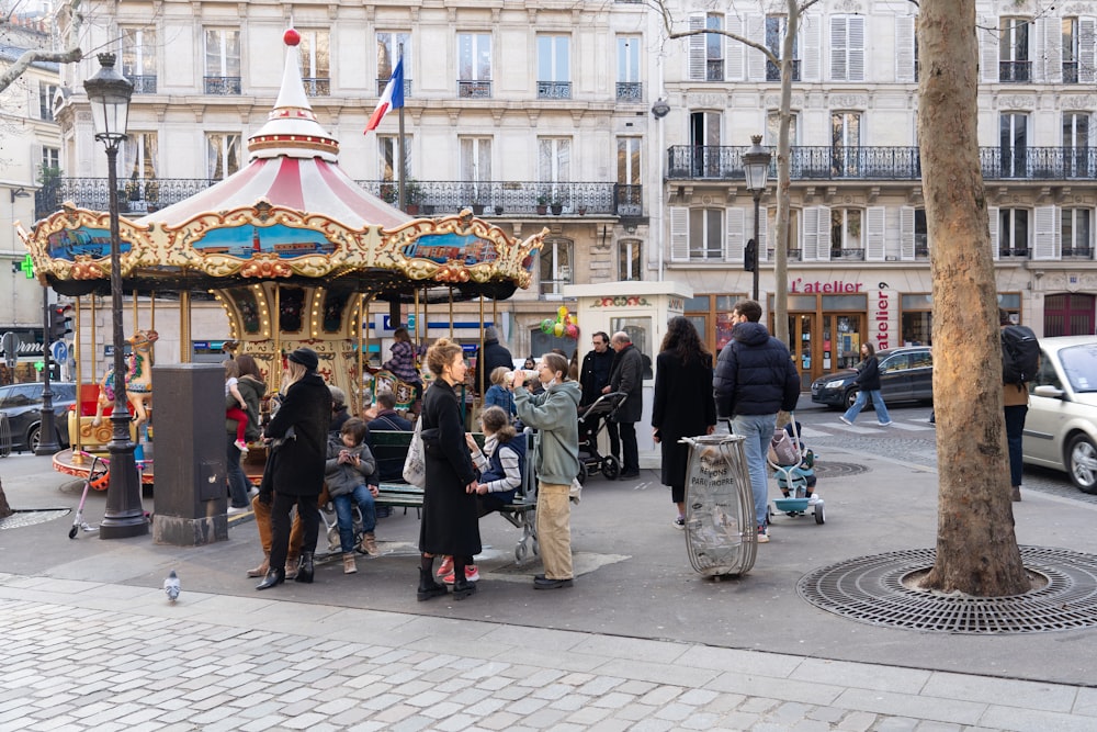 a group of people standing around a merry go round