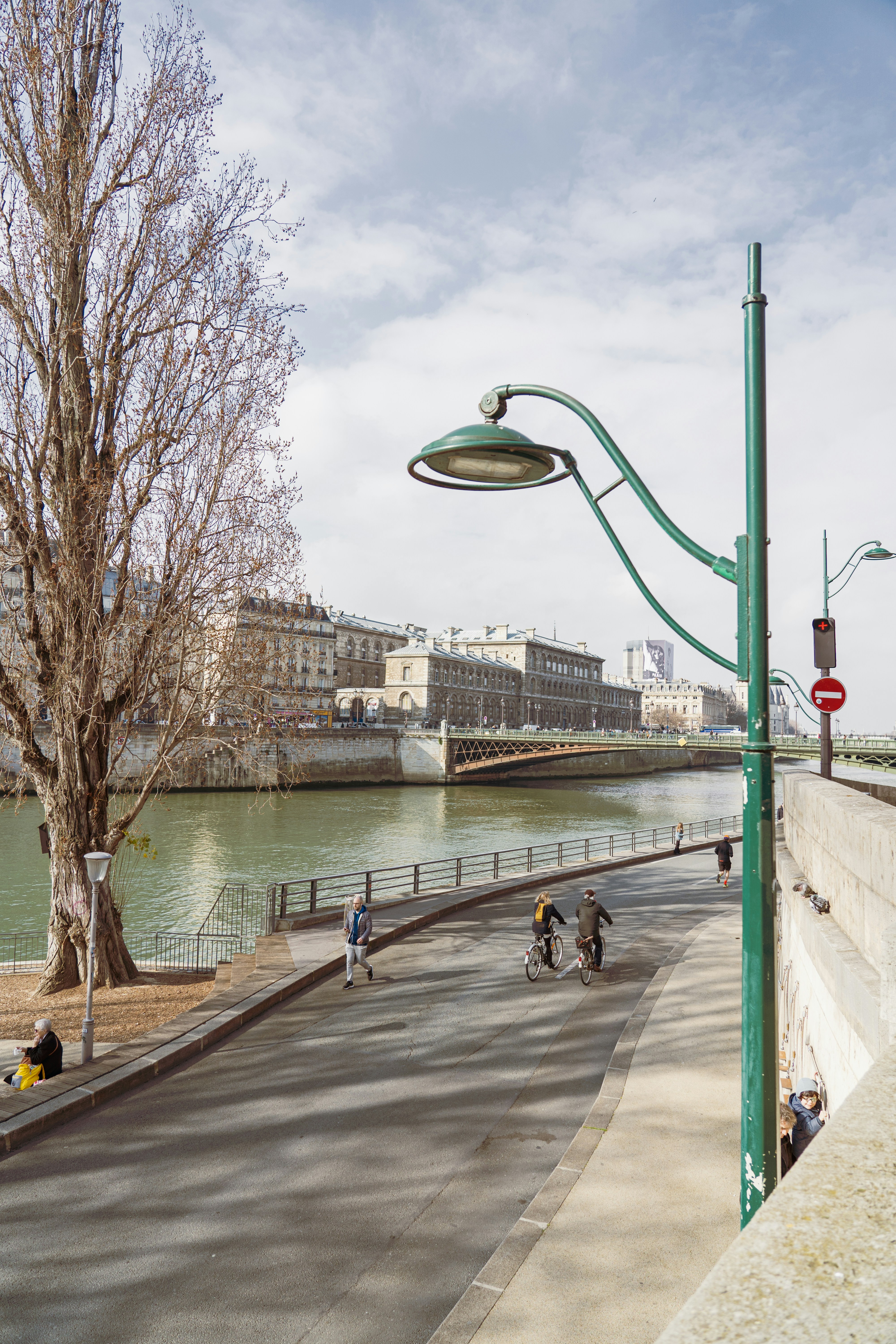 Un gruppo di persone in bicicletta lungo una strada vicino a un fiume