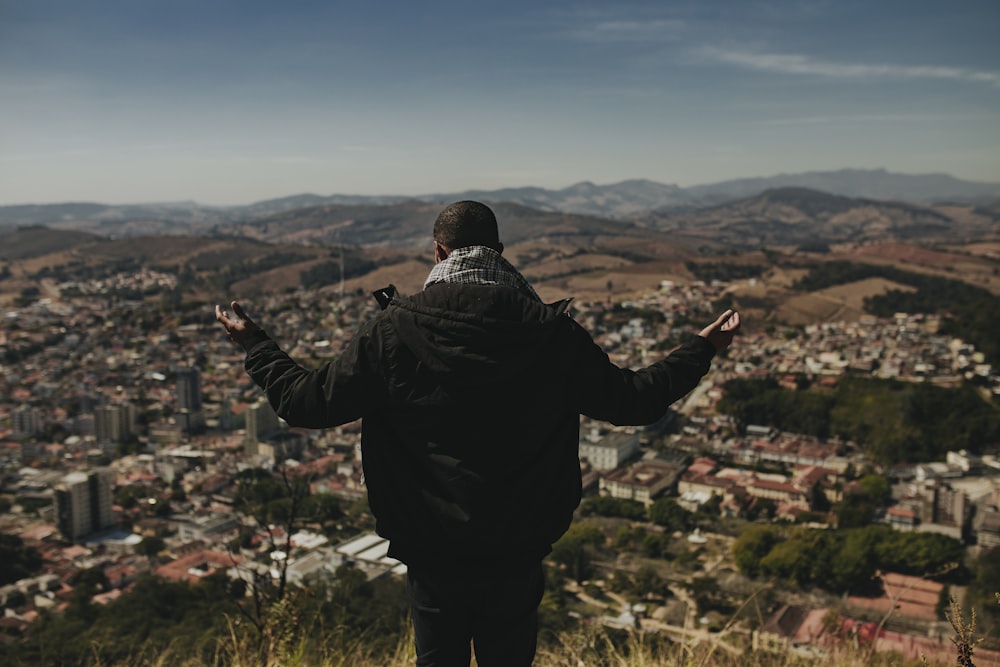 a man standing on top of a lush green hillside