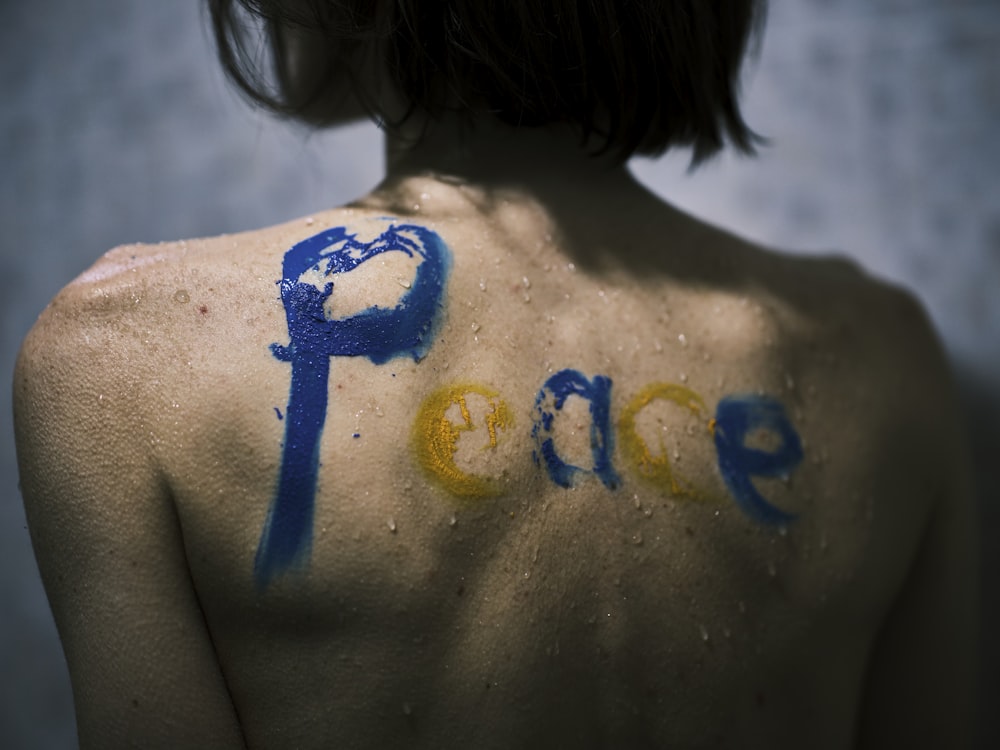 a man with a painted peace sign on his back