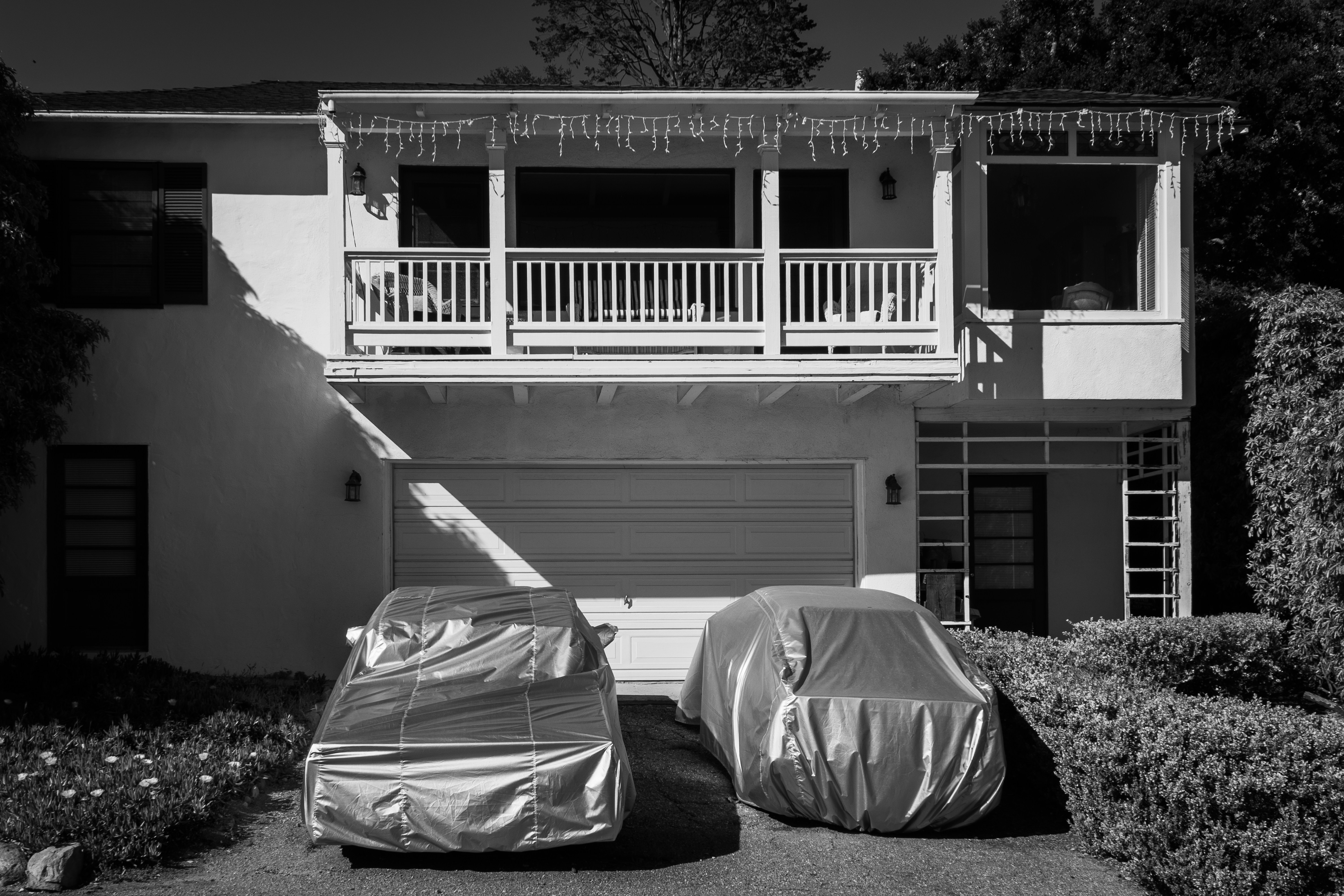 a car covered in a tarp in front of a house