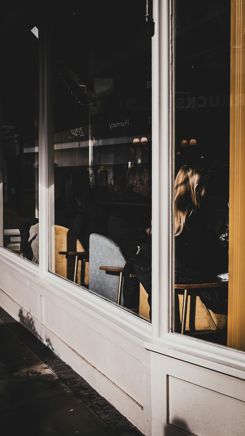 a woman sitting at a table in front of a window