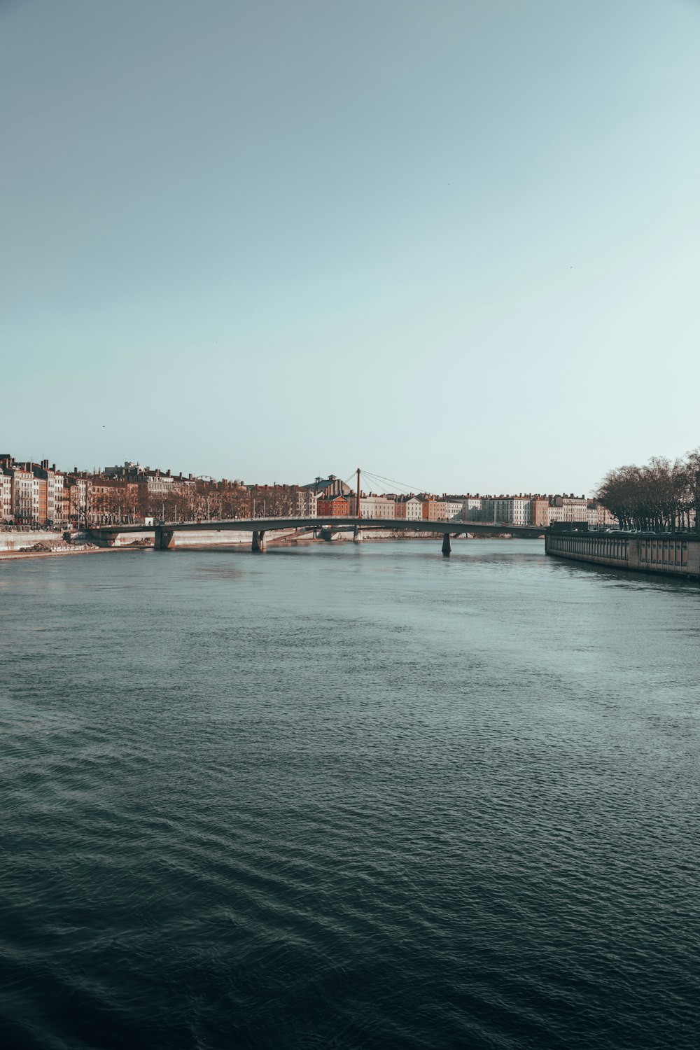 a large body of water with a bridge in the background