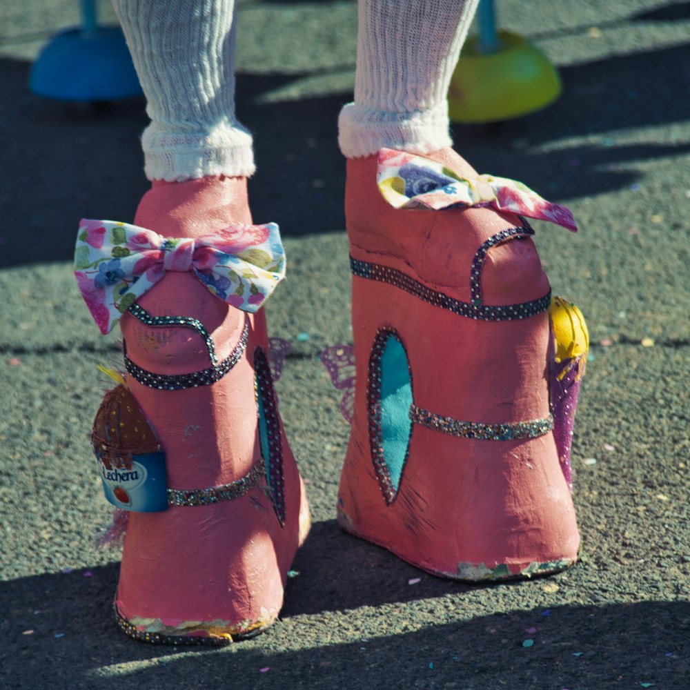 a close up of a person's feet wearing pink shoes