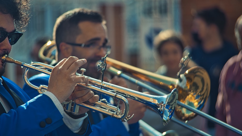 a man playing a trumpet in front of a group of people