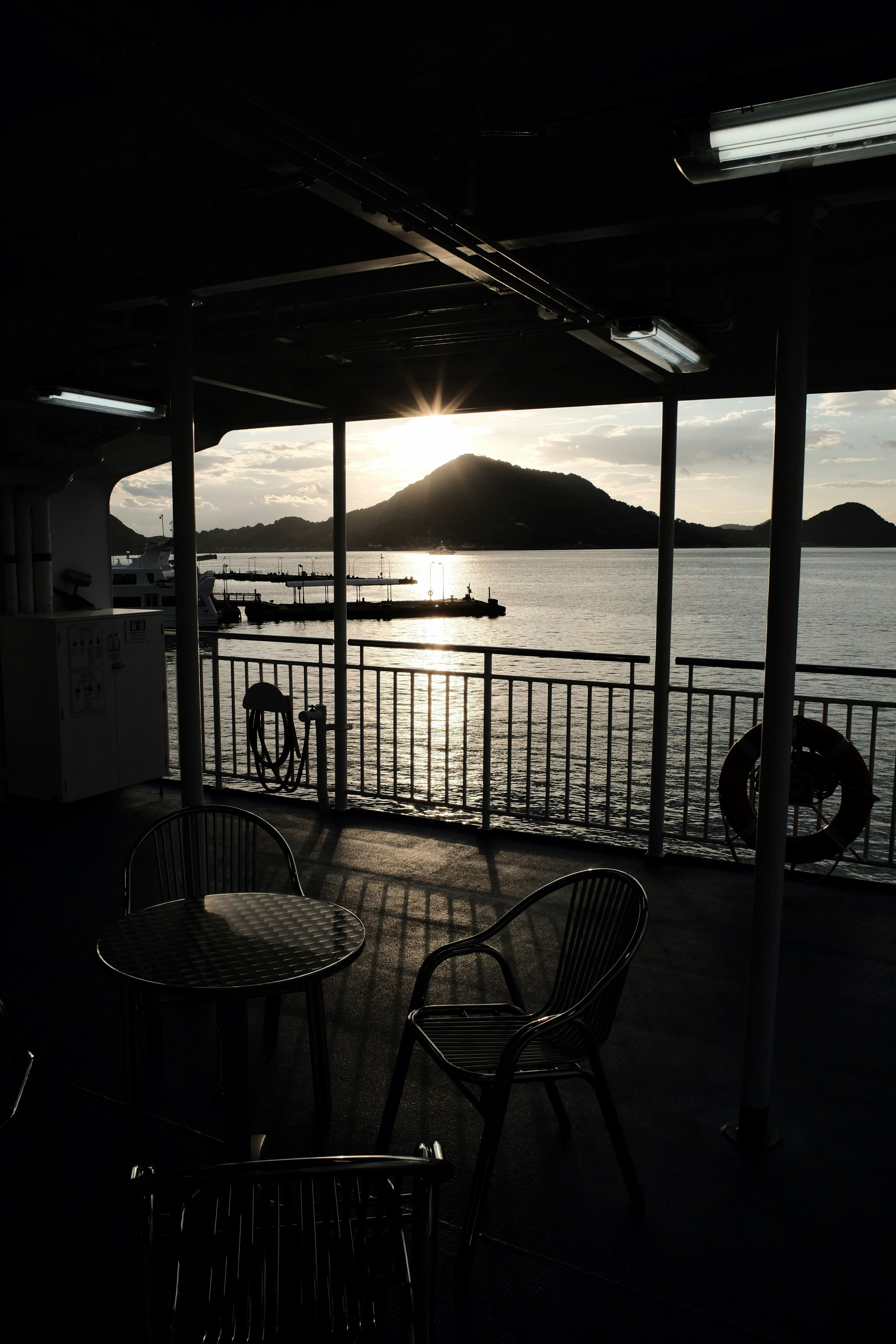A table and chairs on a deck overlooking a body of water photo – Free ...