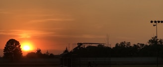 A vibrant sunset over a film shooting location with silhouettes.