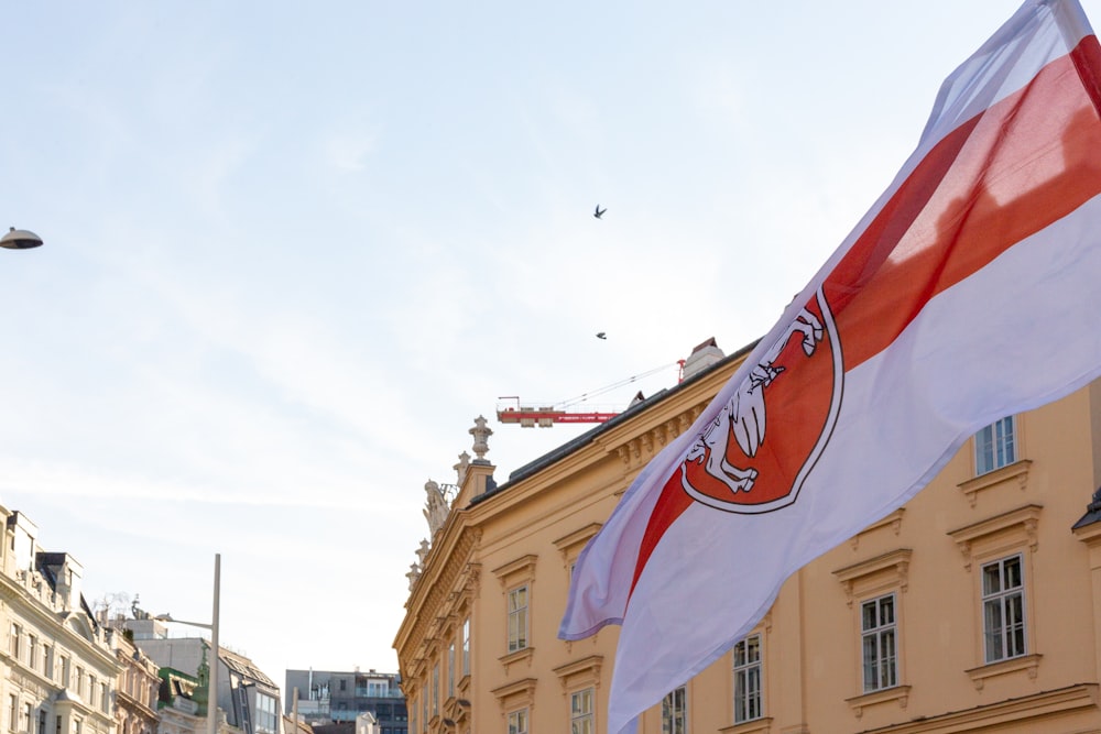 a flag flying in the wind in front of a building