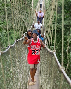a group of people walking across a suspension bridge