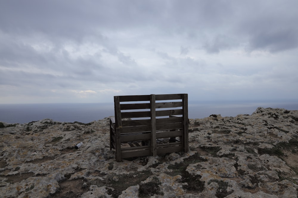 a wooden bench sitting on top of a rocky hill