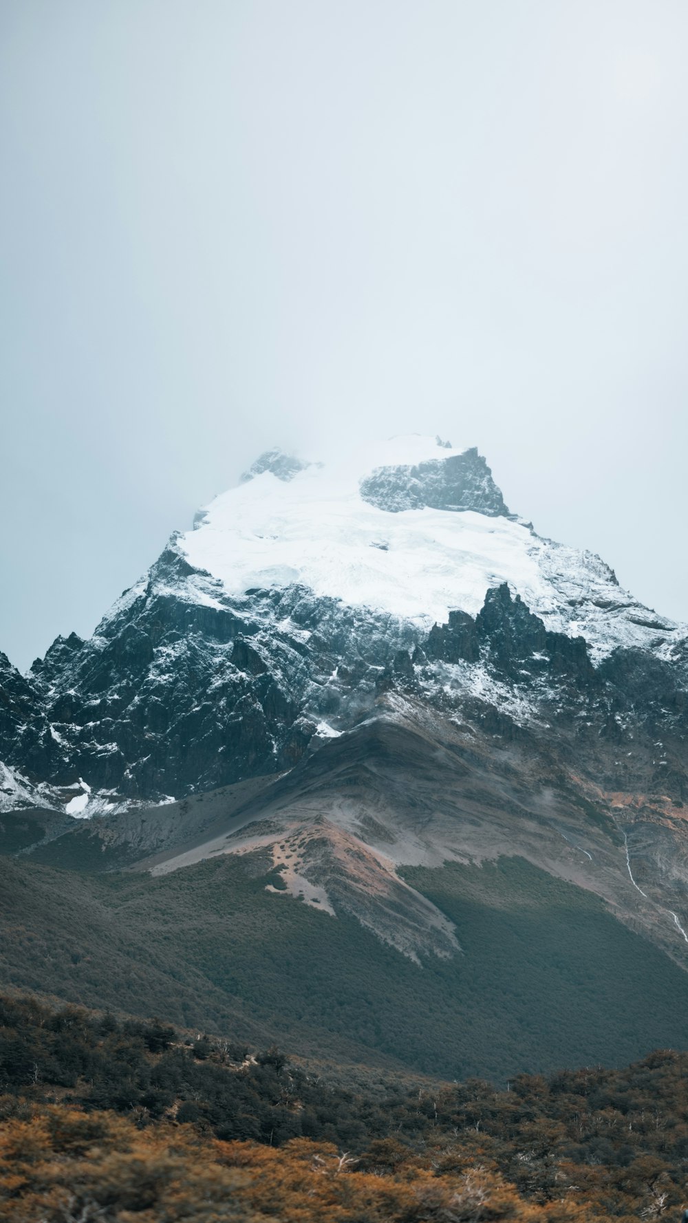 a mountain covered in snow on a cloudy day