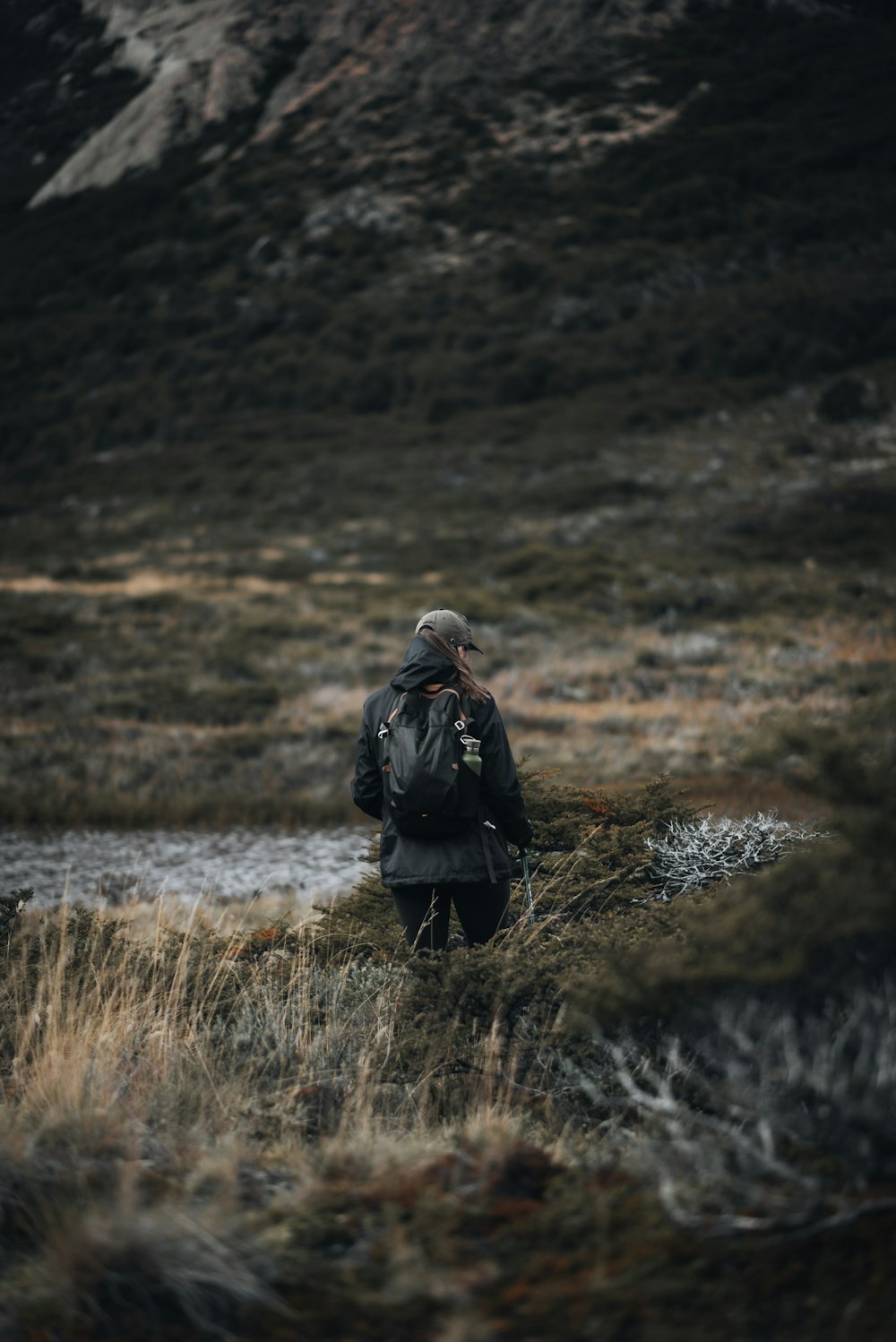 a man with a backpack walking through a field