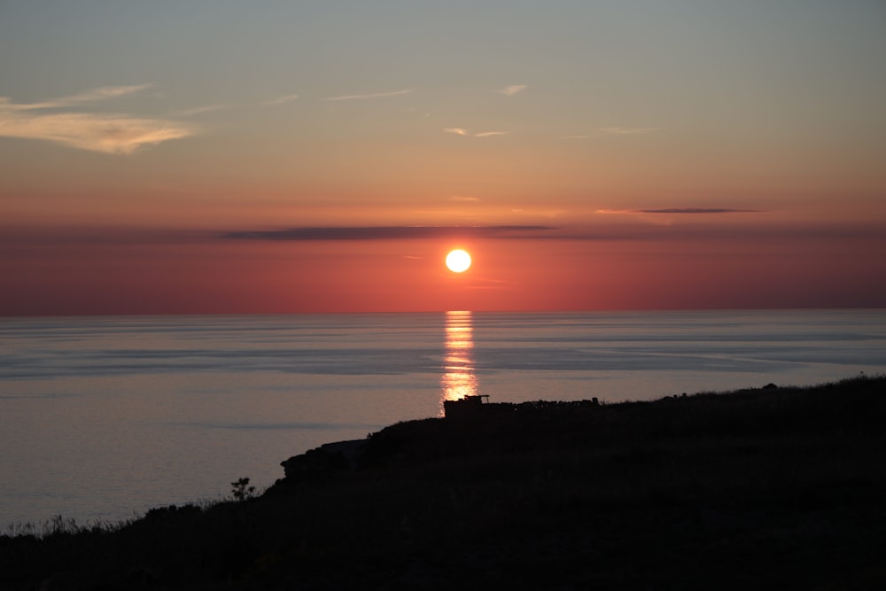 the sun is setting over the ocean on a clear day