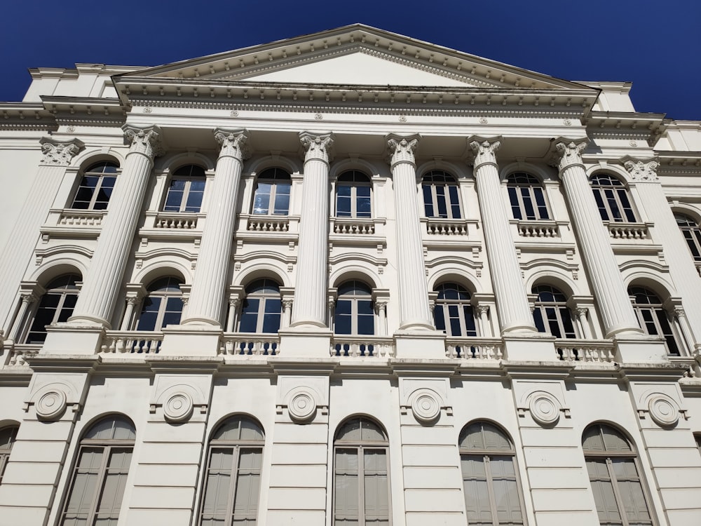 a tall white building with many windows and columns