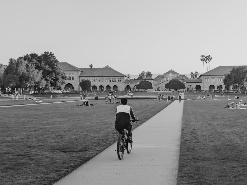 a person riding a bike down a sidewalk