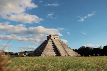 a group of people standing in front of a pyramid