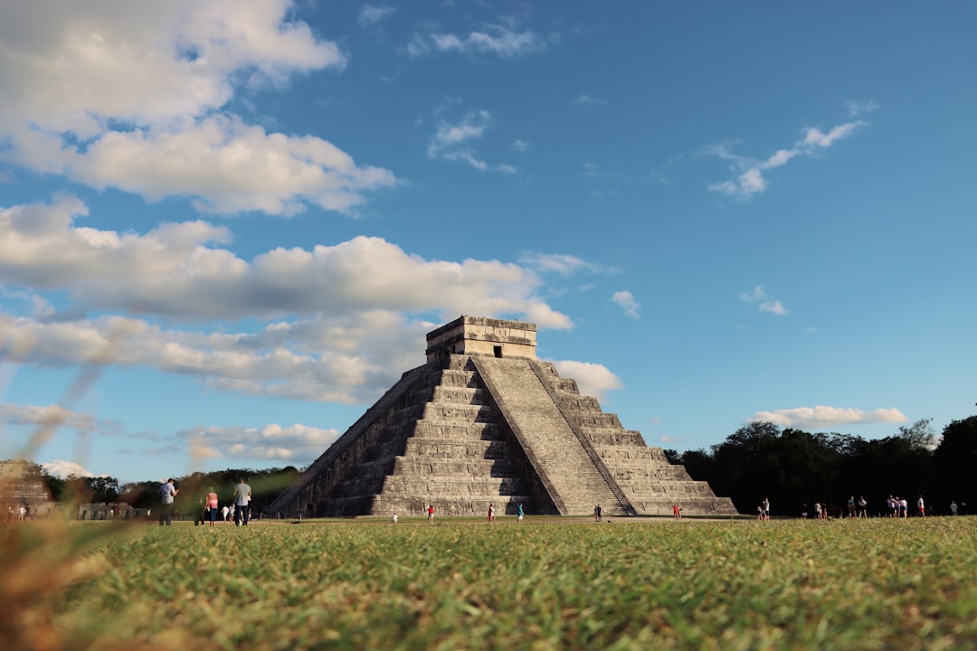 a group of people standing in front of a pyramid,