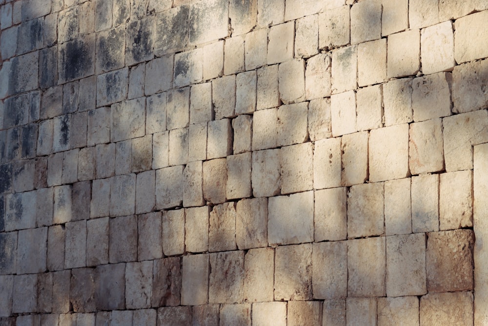 a large brick wall with a clock on it's side