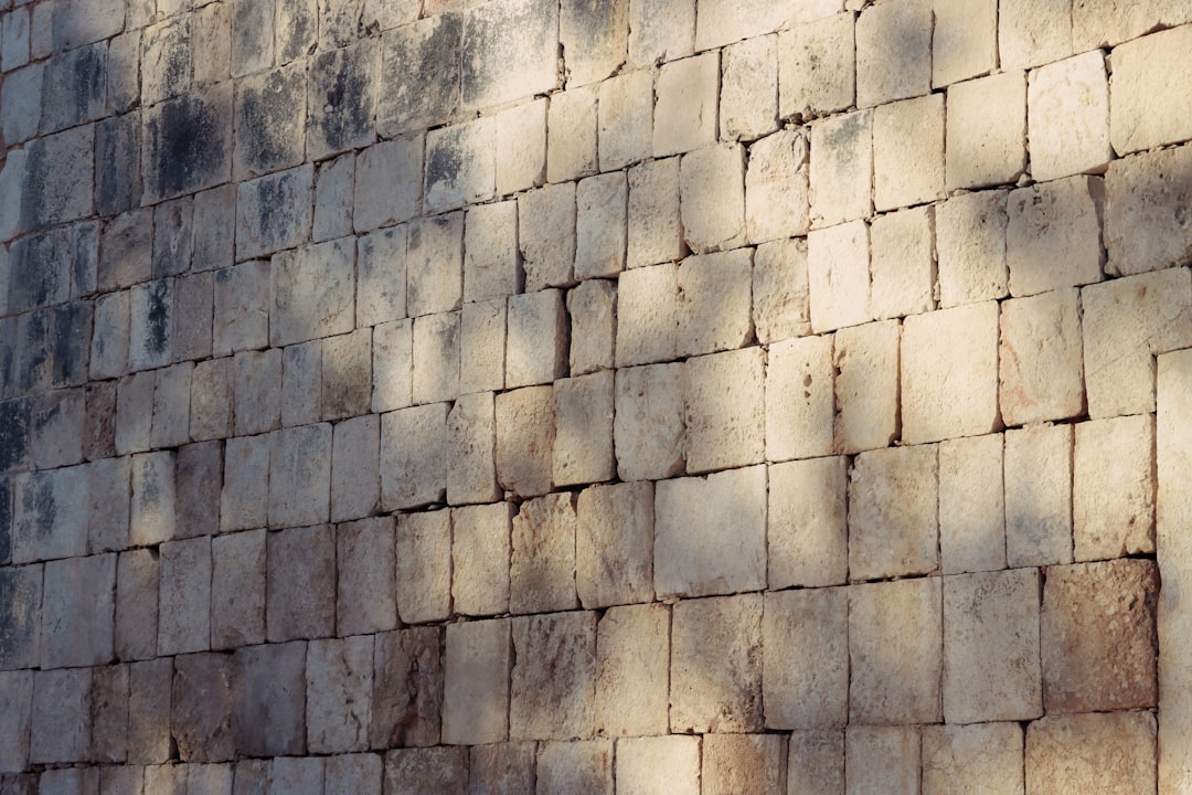 a large brick wall with a clock on it