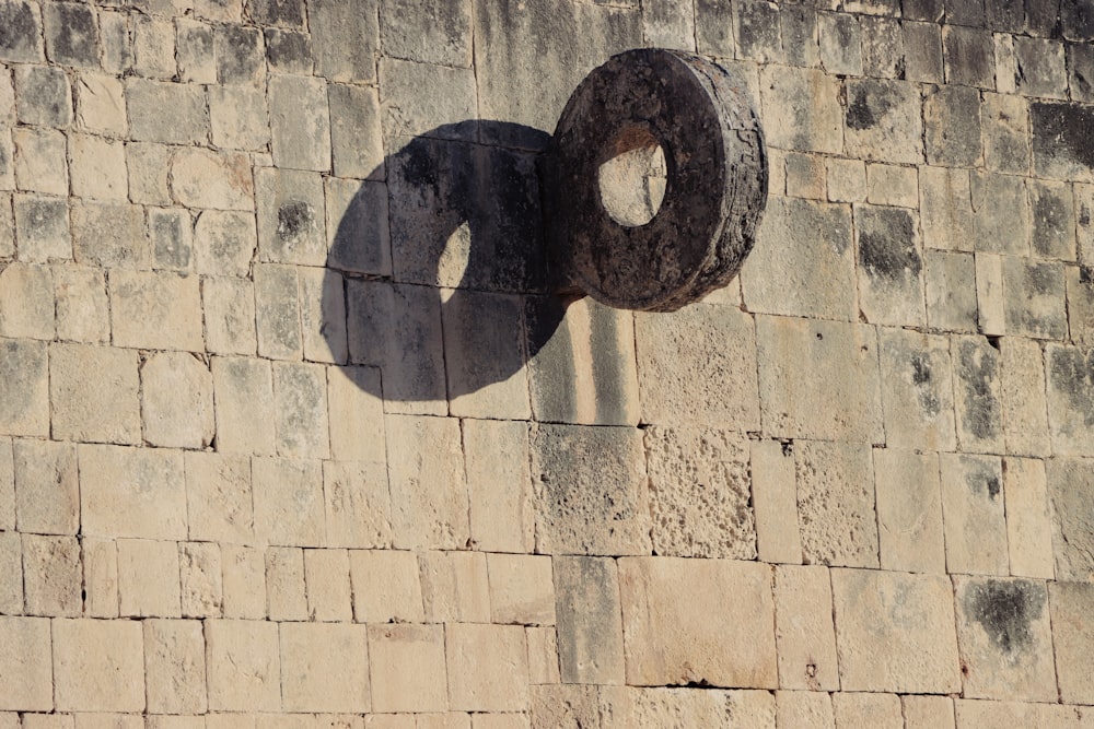 l’ombre d’un objet circulaire sur un mur de briques