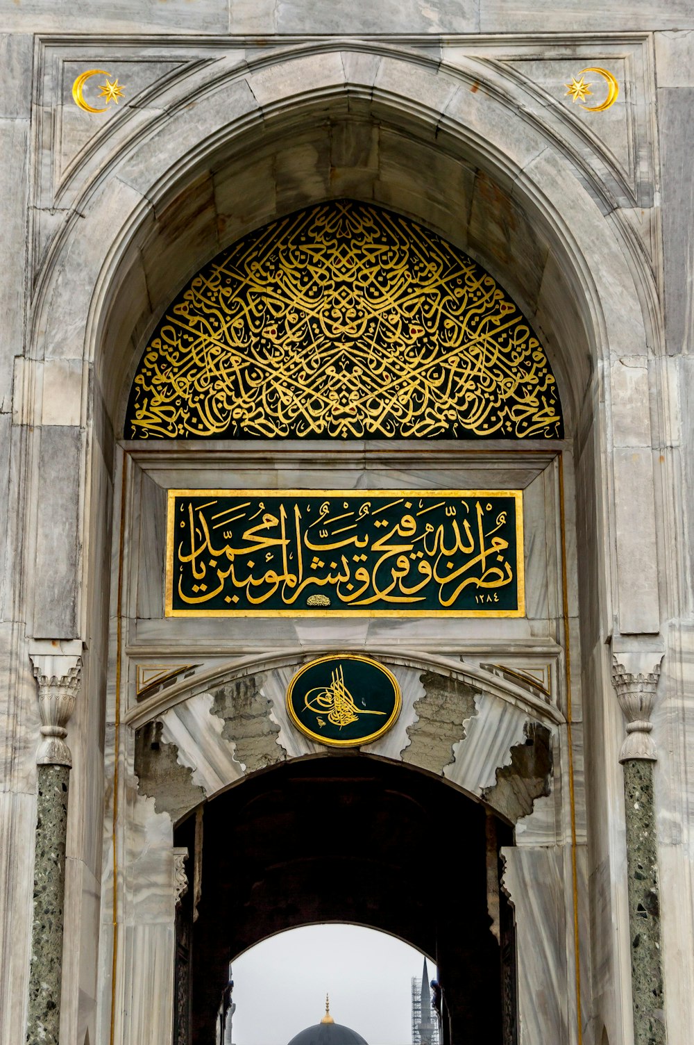 a large archway with a gold and black sign above it